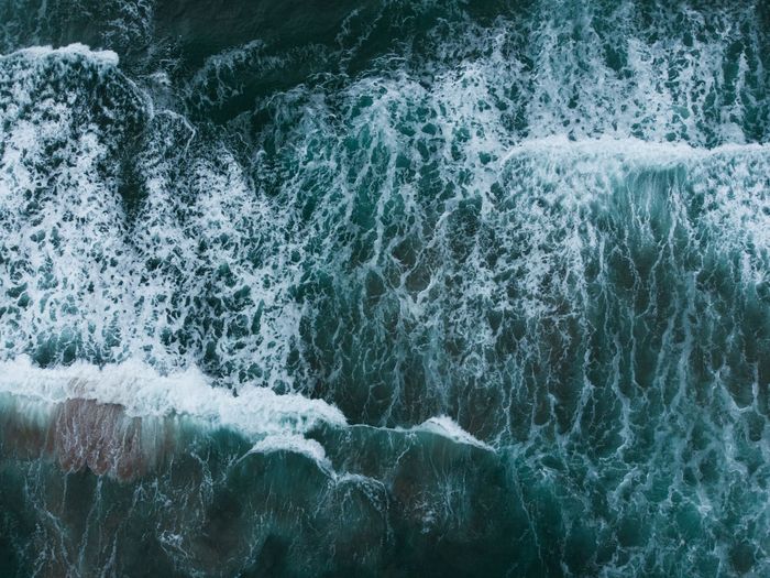 Снимка на бурното черно море, бели и тюркозени вълни, заснети с дрон
